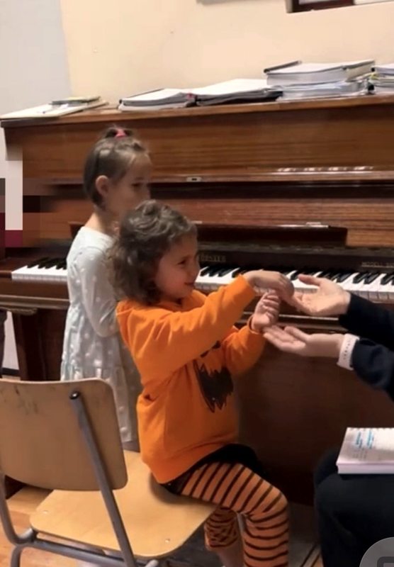 A child engaging in audiation pattern exchange at the piano